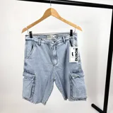 Bermuda de jean celeste con bolsillos cargo laterales y corte a la rodilla.