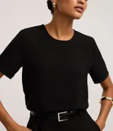 Blusa fucsia de manga corta con cuello redondo pespunteado, diseño sin estampa y efecto airflow con textura sutil. Cuenta con abertura trasera tipo gota y cierre con botón.