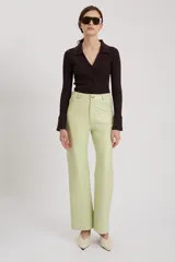 Pantalón de cuero color verde claro, de tiro medio y corte holgado.