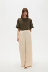 Pantalón de viscosa color beige, de corte ancho, tiro alto y diseño fluido.