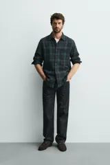 Camisa de corte regular fit confeccionada en tejido doble de algodón, con diseño de cuadros en tonos verde y azul marino. Presenta cuello solapa, manga larga con puño abotonado, bolsillo plastrón en el pecho y cierre frontal con botones.