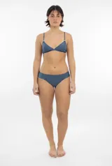 Top de bikini triangular color azul grisáceo con acabado satinado, breteles finos y arandelas metálicas en la unión de los breteles.