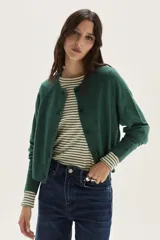 Cardigan de punto en color verde oscuro, con cuello redondo, cierre frontal de botones y mangas largas con puños acanalados.