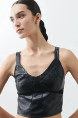 Top negro de cuero sintético con breteles finos y corte ajustado.