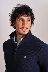 Sweater de punto acanalado color azul marino, con cuello alto y cierre frontal parcial. Presenta el logo de la marca bordado en el pecho y puños con terminación elástica.