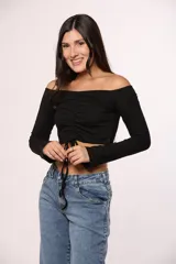 Top de algodón color marrón, con escote off-shoulder, mangas largas y detalle de frunce central con lazo ajustable.