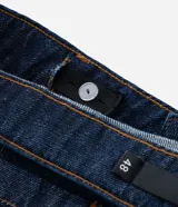 Bermuda tipo jorts de corte amplio y tiro medio, confeccionada en denim de algodón azul oscuro. Presenta diseño de cinco bolsillos, cierre frontal con botón y costuras en tono contrastante.