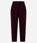 Pantalón zanahoria color borgoña de crepé de poliéster, con trabillas en la cintura, cierre tradicional, pliegues y bolsillos.
