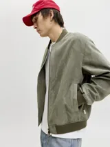 Campera bomber color verde militar, con cierre frontal, cuello, puños y ruedo de rib elástico.