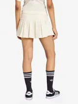 Falda mini de estilo tenista color blanco, con diseño plisado y talle bajo. Presenta el logo de la marca bordado en la parte frontal y cierre lateral.