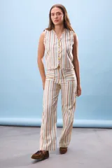 Pantalón de tiro alto con pierna recta y estampado de rayas verticales en tonos beige, marrón oscuro, rosado pálido y celeste. Presenta bolsillos delanteros con solapa.