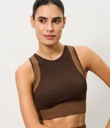 Top deportivo Get Over confeccionado en microfibra seamless de color marrón, con diseño ajustado, escote redondo, sin mangas y recortes contrastantes en tono tostado.
