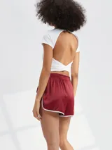 Short deportivo de satén color bordó con cintura elástica y ribetes blancos en los bordes.