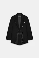 Blazer Zara Woman Collection de corte asimétrico, con cuello de solapa, cierre frontal de doble botonadura y mangas largas. Presenta un diseño estructurado con bajo irregular y abertura en la espalda.