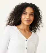 Cardigan blanco de punto con botones negros, escote en V y mangas largas. Marca Blue Steel.