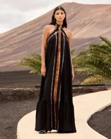 Vestido largo negro de viscosa fluida con cuello halter y espalda descubierta. Presenta un diseño vaporoso con un panel frontal y trasero con estampado difuminado en tonos tostados y azulados, y un volante fruncido en el bajo.