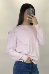 Buzo de hilo de punto fino en color rosado, con cuello redondo, mangas largas y detalle de volados en los hombros.