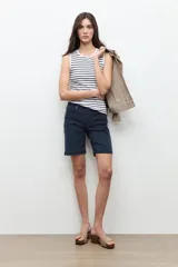 Bermuda de denim negro de tiro medio, con diseño clásico de cinco bolsillos y largo hasta las rodillas.