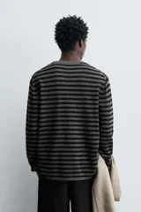 Jersey de corte relajado confeccionado en hilatura con mezcla de lana y cashmere. Presenta diseño de rayas horizontales, cuello redondo y manga larga con acabados en rib.