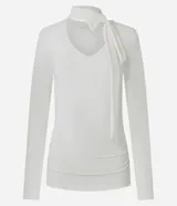 Blusa entallada de microfibra color blanco, con escote en V, mangas largas y detalle de frunces en los laterales. Presenta un lazo integrado en el cuello que permite anudarlo, aportando un toque sofisticado al diseño.