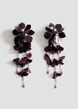 Aros colgantes largos de diseño floral en color violeta oscuro. Presentan múltiples capas de pétalos metálicos y acrílicos, adornados con pequeñas perlas y cristales colgantes en los extremos.