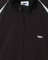 Campera tipo rompevientos de la marca Obey, con diseño a cuadros pequeños en tonos azul y blanco. Presenta cuello alto, cierre frontal completo, bolsillos laterales y detalles de líneas negras contrastantes que recorren el frente y las mangas. Incluye el logo de la marca bordado en el pecho.