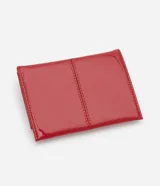 Billetera de mano Satinato tipo sobre, de color rojo con acabado barnizado y costuras decorativas. Cuenta con cierre de botón a presión.