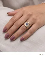 Anillo ancho confeccionado en plata 925 con lámina de oro 18k en los bordes y acabado texturizado, decorado con una circonia cuadrada central de color azul.