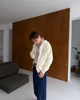 Campera con cierre frontal de Nude Project, confeccionada en algodón de alto gramaje con diseño oversized. Presenta capucha, bolsillos tipo canguro y un parche bordado con las iniciales NP en el pecho.