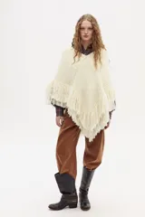 Poncho tejido en lana merino multicolor con escote en V y flecos decorativos en el ruedo.