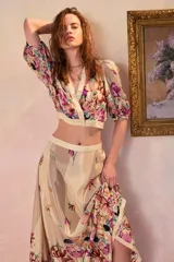 Top corto cruzado de viscosa con escote en V, mangas cortas abullonadas y diseño estampado con flores multicolores sobre fondo beige.