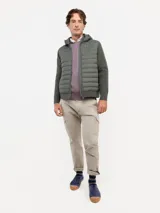 Chaqueta híbrida para hombre con frente acolchado de nylon y mangas de tejido de punto. Cuenta con cierre frontal, capucha y puños acanalados.