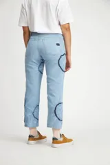 Pantalón de jean celeste con estampado tye dye azul oscuro en los laterales.