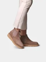 Botin de mujer de cuero negro, estilo chelsea, con elásticos laterales, tirador trasero y suela dentada de goma color caramelo.