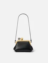 Cartera de cuero negro tipo sobre, con silueta abombada y marco metálico superior. Cuenta con broche de pinza decorado con una esfera plateada y un cubo dorado, correa fina desmontable y forro interior con tarjetero.