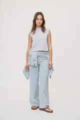 Pantalón wide leg de tiro medio con estampado de rayas verticales, diseño de cinco bolsillos, presillas para cinto y cierre frontal con botón y cremallera.
