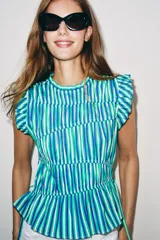 Top sin mangas de cuello redondo, con estampado de rayas verticales en tonos verdes, azules y blancos. Presenta volantes en las sisas, costuras fruncidas en el cuerpo y detalles de lazos ajustables en el bajo.