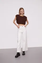 Chaleco corto de punto color marrón con ribete amarillo en cuello, sisas y bajo.