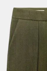 Pantalón recto de tiro bajo en color verde militar, con nervios marcados en la parte delantera, bolsillos frontales y cierre con cremallera, botón interior y ganchos.