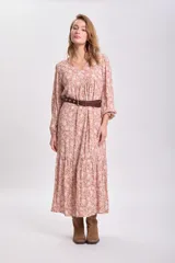 Vestido largo color tostado con estampado floral blanco, corte holgado, mangas largas abullonadas y cinturón marrón.