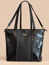 Cartera shopper de cuero color negro con diseño texturizado estilo croco en los laterales y textura lisa en el panel central. Cuenta con doble asa de hombro, correa larga desmontable con herrajes metálicos dorados y placa frontal con el logo de la marca Valdez.