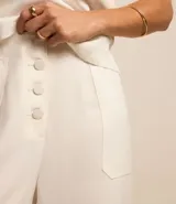 Pantalón pantacourt de viscosa color blanco, con bolsillos laterales y cierre con botones delanteros.