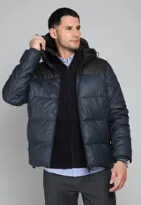 Campera inflada azul marino y negra con capucha, cierre frontal y bolsillos laterales con cierre.