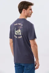 Remera gris oscuro de manga corta y cuello redondo, con un estampado gráfico en la espalda que incluye un paisaje de montaña y la leyenda "Take time to chill vibes cool down".