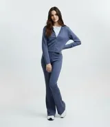 Pantalón flare de tiro alto con cintura ancha, confeccionado en microfibra elástica. Presenta un corte ajustado en caderas y muslos con una silueta acampanada desde la rodilla.