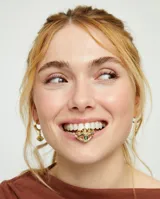Anillo dorado con forma de ojo y cristal facetado verde. Fabricado en aleación de metales bañado en oro 18k.