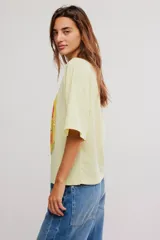 Remera oversize de algodón color amarillo claro, con escote redondo, mangas cortas amplias y hombros caídos. Cuenta con estampa ilustrada al frente de una lata de tomates.