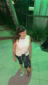 Pantalón capri ajustado color verde oscuro con estampado de lunares rosados. Tiene elástico en la cintura y un cierre lateral.