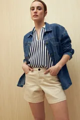 Short de gabardina color beige, de tiro alto y corte recto, con bolsillos laterales y cierre frontal con botón.