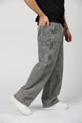 Jean baggy de hombre color gris, con diseño holgado, estilo cargo y parches en las rodillas.